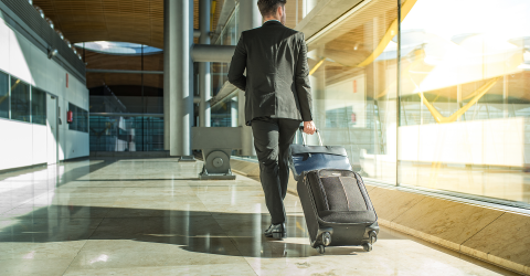 Een zakenman loopt met zijn koffer op een luchthaven